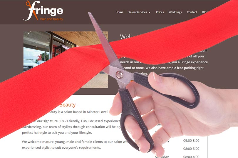 A ribbon is cut over an image of the new Fringe Hair & Beauty website